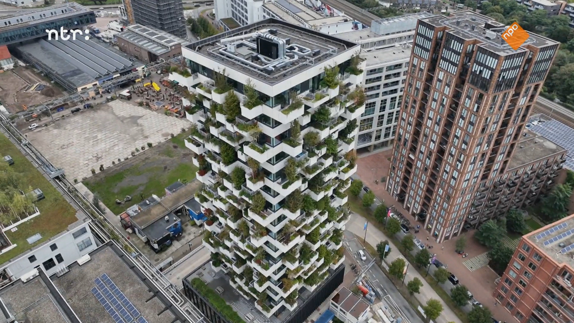 a tall building with many plants on the top